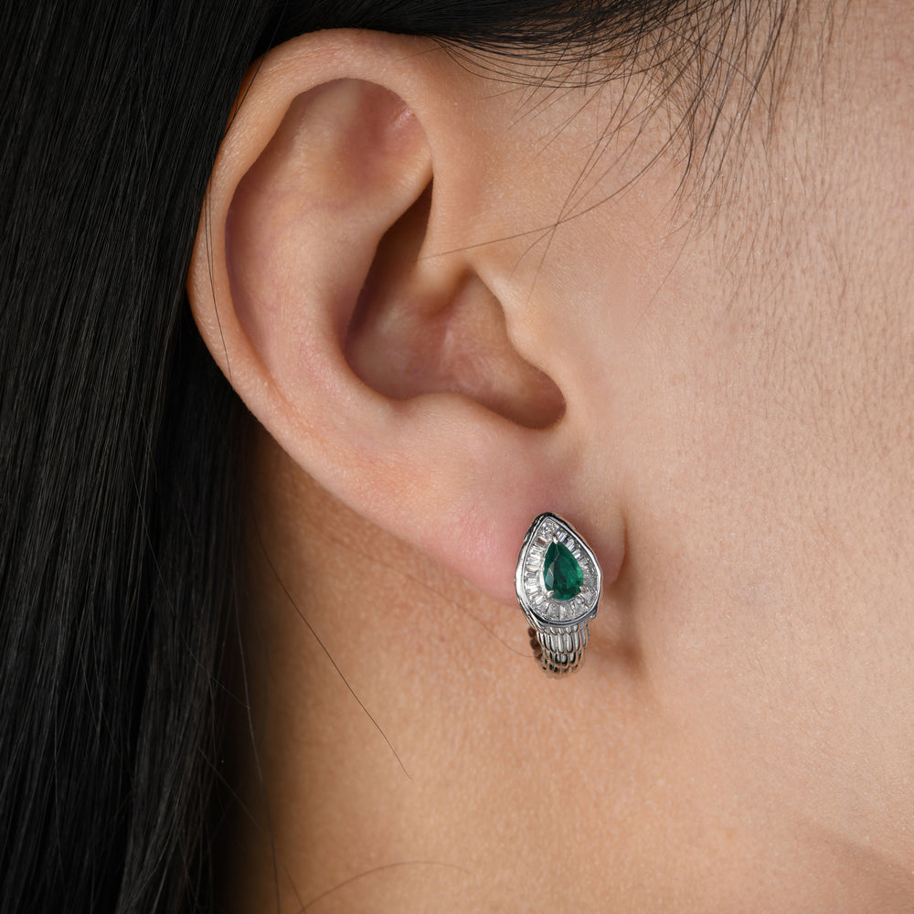 snake-inspired earrings, where the meticulously crafted snake head design is adorned with a mesmerizing emerald at its center, encircled by a halo of radiant white simulated diamonds. The engraved band, mirroring the texture of a snake, completes the design, creating a captivating accessory that seamlessly merges nature-inspired elegance with timeless sophistication.