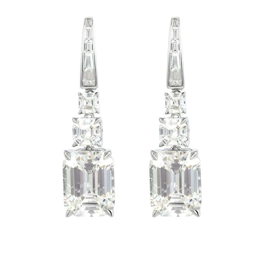 Elevate your look with our dazzling pair of drop earrings featuring a sizable emerald-cut white simulated diamond, suspended alongside two smaller stones. This design showcases the allure of big, shiny, and clear stones, adding a touch of glamour to any ensemble.