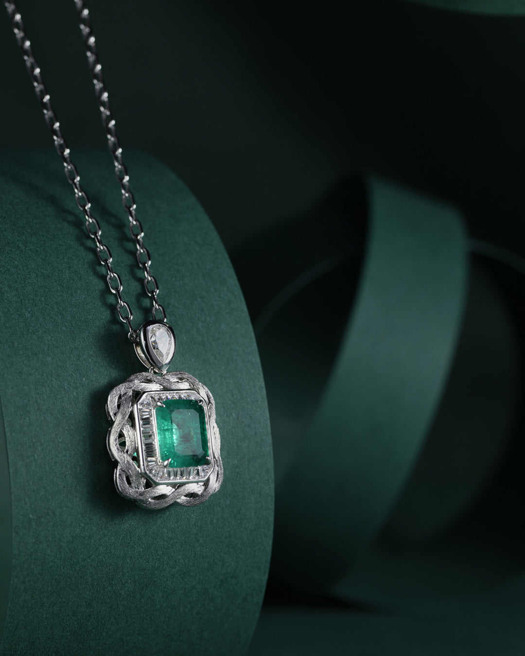 Emerald Nestled Amidst Finely Engraved Metal Lines Pendant