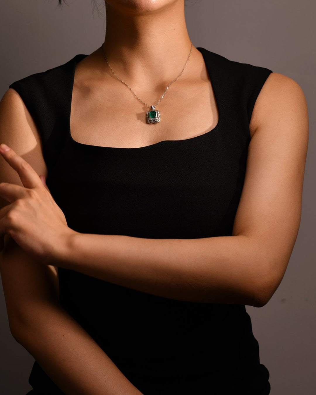 Emerald Nestled Amidst Finely Engraved Metal Lines Pendant