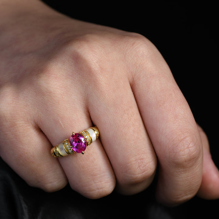 This exquisite ring featuring a central oval ruby set on a golden band adorned with alternating stripes of dazzling melee diamonds and white agate. The harmonious combination of vibrant colors and textures makes this ring a statement piece.